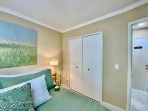 a bedroom with a green couch and a closet at Beautiful Days in Orange Park