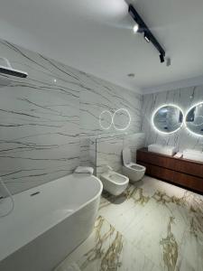 een badkamer met een bad, een toilet en een wastafel bij KNIGHT Resort in Voluntari