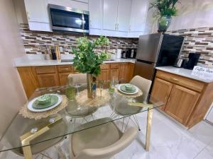 a kitchen with a glass table with chairs and a refrigerator at Beautiful Days in Orange Park