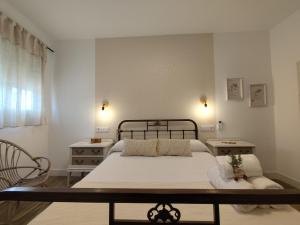 un dormitorio con una cama, dos mesas y una ventana en Casa Cisca, en Quesada