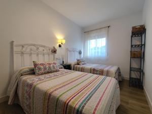 un dormitorio con dos camas y una ventana en Casa Cisca, en Quesada