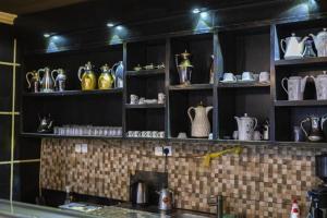a kitchen with shelves filled with vases and pitchers at Quiet Rooms 8 Serviced Apartments in Riyadh