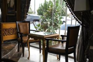a table with two chairs and a vase on it at Quiet Rooms 8 Serviced Apartments in Riyadh