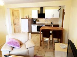 een woonkamer met een bank en een tafel en een keuken bij Ranchhaus in Baumannsberg