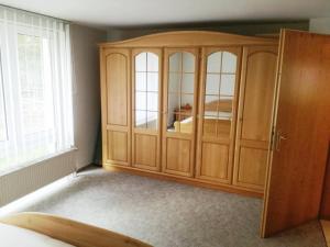 een houten kast in een kamer met een raam bij Ranchhaus in Baumannsberg