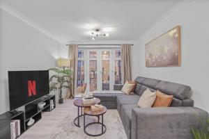 a living room with a couch and a tv at Modern 2 Bed Apartment, Secure Parking, Central in Hemel Hempstead