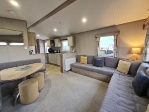 a living room with a couch and a table at Silversands - Private Caravan Let in Lossiemouth