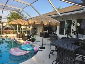 een terras met een zwembad met opblaasbare boten erin bij Ocean Spa Retreat in Port Saint Lucie