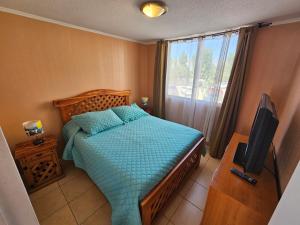 a bedroom with a bed with a television and a window at Arriendo Departamento Diario en Copiapo in Copiapó