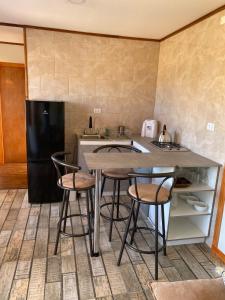 a kitchen with a table and four chairs and a refrigerator at Cabaña Palmas de Tunquen in Tunquén