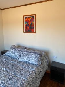 a bedroom with a bed and a picture on the wall at Cabaña Palmas de Tunquen in Tunquén +10 photos