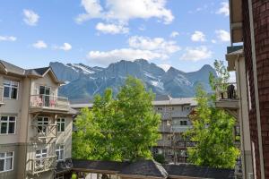 a view of mountains from buildings in a city at 2 Bedroom Condo Banff, Canmore sleeps 6 comfortably in Canmore
