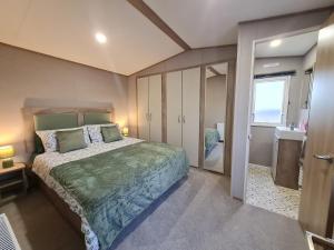 a bedroom with a large bed and a bathroom at Silversands - Private Caravan Let in Lossiemouth