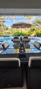 een tafel met een parasol en stoelen naast een zwembad bij Ocean Spa Retreat in Port Saint Lucie