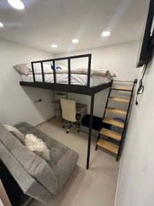 伊瓦格Casa Mantra的一间卧室配有双层床和沙发 更多3张照片