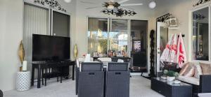 een woonkamer met een televisie en een piano bij Ocean Spa Retreat in Port Saint Lucie