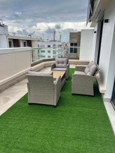 een balkon met 2 stoelen en een tafel en gras bij Agdotel Urban Suites in Rabat