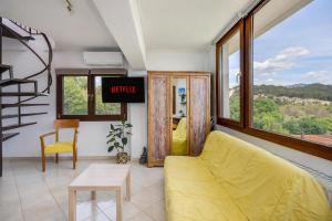 un soggiorno con divano giallo e finestra di Studio Acropolis Serres With Parking Next to Center a Serres Altre 43 foto