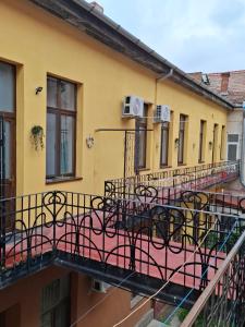 a yellow building with a balcony with chairs on it at Art Nouveau Aparthotel in Oradea