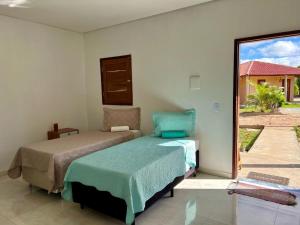 a bedroom with two beds and a large window at pousada chales vale do catimbau in Buíque