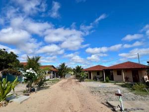 a dirt road in front of some houses at pousada chales vale do catimbau in Buíque