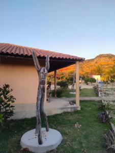 a statue of a person with their arms in the air at pousada chales vale do catimbau in Buíque