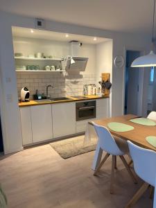 a kitchen with a wooden table and a dining room at Cosyinlaboe in Laboe