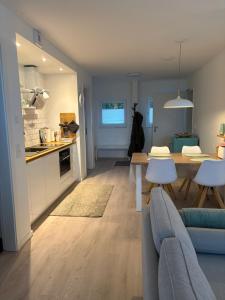 a kitchen and living room with a couch and a table at Cosyinlaboe in Laboe