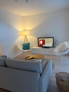 a living room with a couch and a tv at Cosyinlaboe in Laboe +9 photos