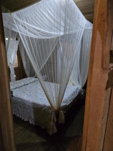a bedroom with a bed with mosquito net at Landscape-Cabaña winter full equipada in La Cruz