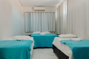 een ziekenhuiskamer met 3 bedden en een raam bij Hotel A BARCA in Bom Jesus da Lapa