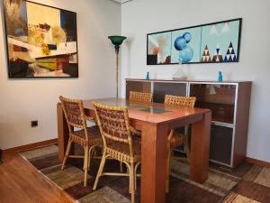 a dining room with a wooden table and chairs at O lar da luz in Ourense