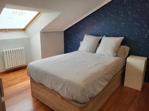a bedroom with a large bed with a blue wall at O lar da luz in Ourense +18 photos