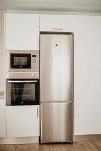 a kitchen with a refrigerator and a microwave at Villa alegre in Elche