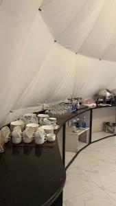 a group of cups and bowls on a table in a tent at RUM NADINE LUXURY CAMP & Bubbles Hotel in Wadi Rum