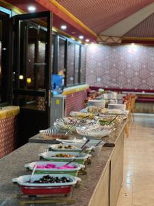 a buffet line with many plates of food on at RUM NADINE LUXURY CAMP & Bubbles Hotel in Wadi Rum