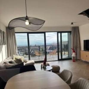 a living room with a table and a large window at BeskidView Meszna 2 in Meszna