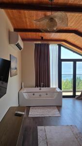a large white tub in a room with a large window at Bella Vista Rezidence in Pogradec