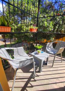 twee witte stoelen en een tafel op een patio bij Refugio Encantador in Santo Domingo