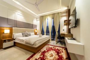 a bedroom with a bed and a desk and a rug at Celestia Grand in Lucknow