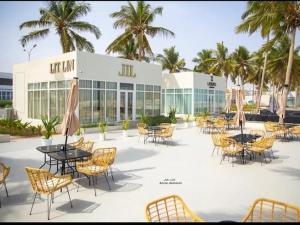 un gruppo di tavoli e sedie di fronte a un edificio di SeaViewApartment a Salalah