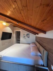 a bedroom with a large bed with a wooden ceiling at Bella Vista Rezidence in Pogradec +54 photos