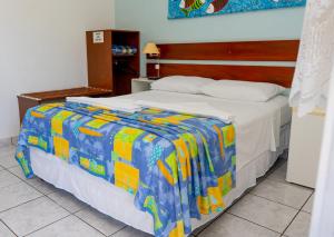 un letto con una coperta colorata in una stanza di Pousada do Rei a Ubatuba