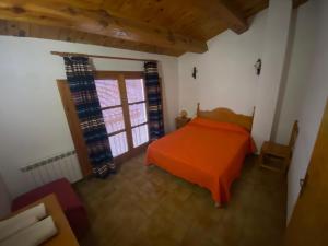 una camera da letto con un letto arancione e una finestra di Casa Alta 14 B a Palanques