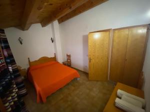 una camera con letto arancione e armadio di Casa Alta 14 B a Palanques Altre 5 foto