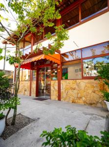 un edificio con una parete in pietra e una porta in vetro di Pousada do Rei a Ubatuba Altre 27 foto