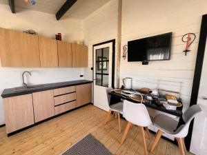 a kitchen with a table and chairs and a television at Pond Cabin  +22 photos