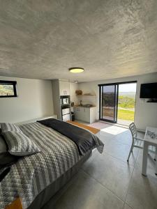 a bedroom with a bed and a table and a window at Protea32 in Agulhas