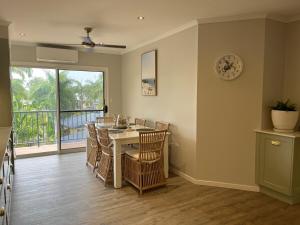 a dining room with a table and chairs and a window at Beach Road Bliss- Whitsundays in Cannonvale