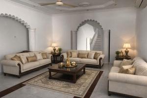 een woonkamer met twee banken en een salontafel bij Amour Hostel in Seeb